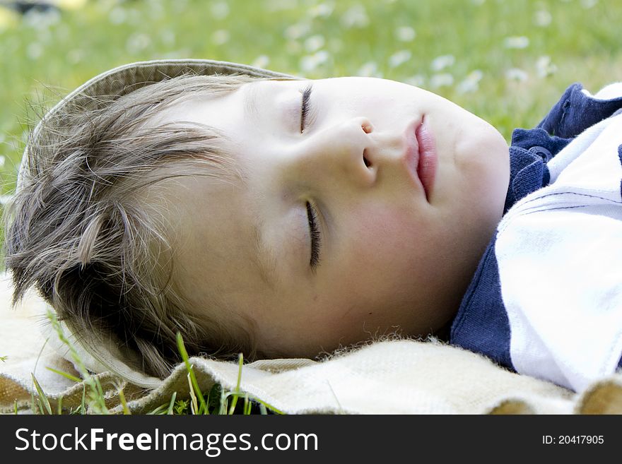 Young boy sleeping in the green grass. Young boy sleeping in the green grass.