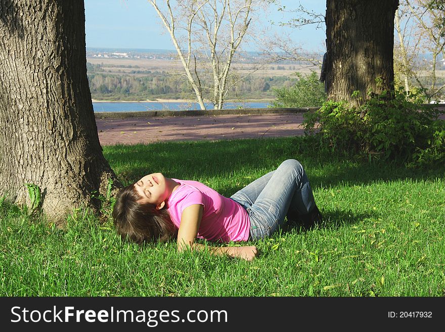 Young woman is lying on a grass