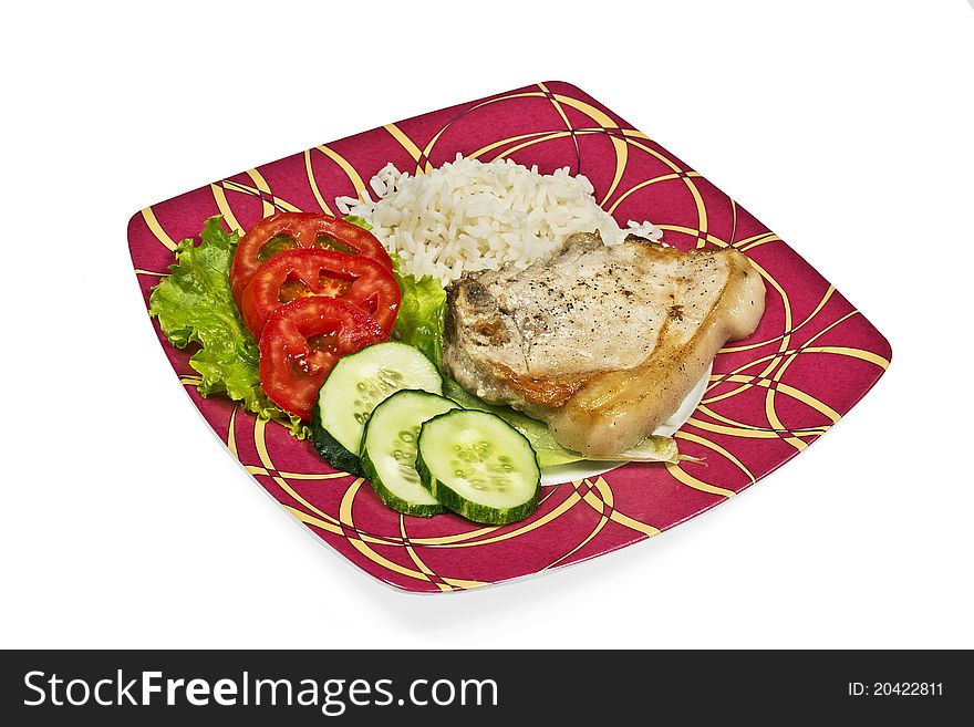 Meat with vegetables and rice on red plate