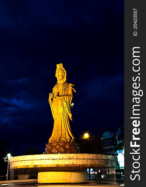 This Guan Yim image is in the center of Khonkaen province, Thailand. It stand on the fountain at the entrance of the park. This picture was captured on a night of cloudy sky. This Guan Yim image is in the center of Khonkaen province, Thailand. It stand on the fountain at the entrance of the park. This picture was captured on a night of cloudy sky.