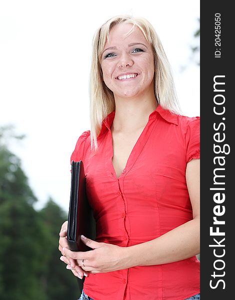 The image of young smiling girl with documents in a folder