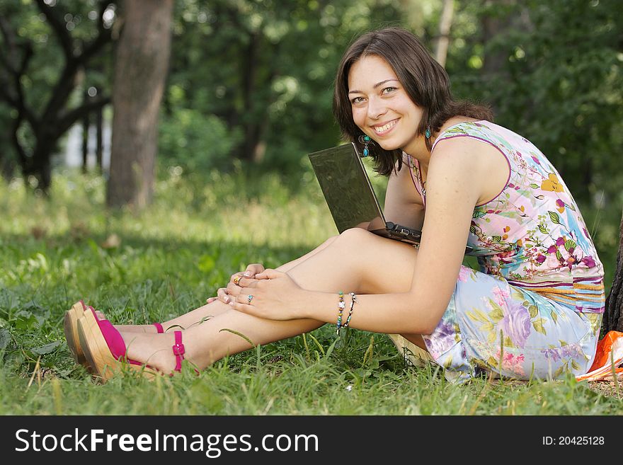 The image of a girl sits on a grass