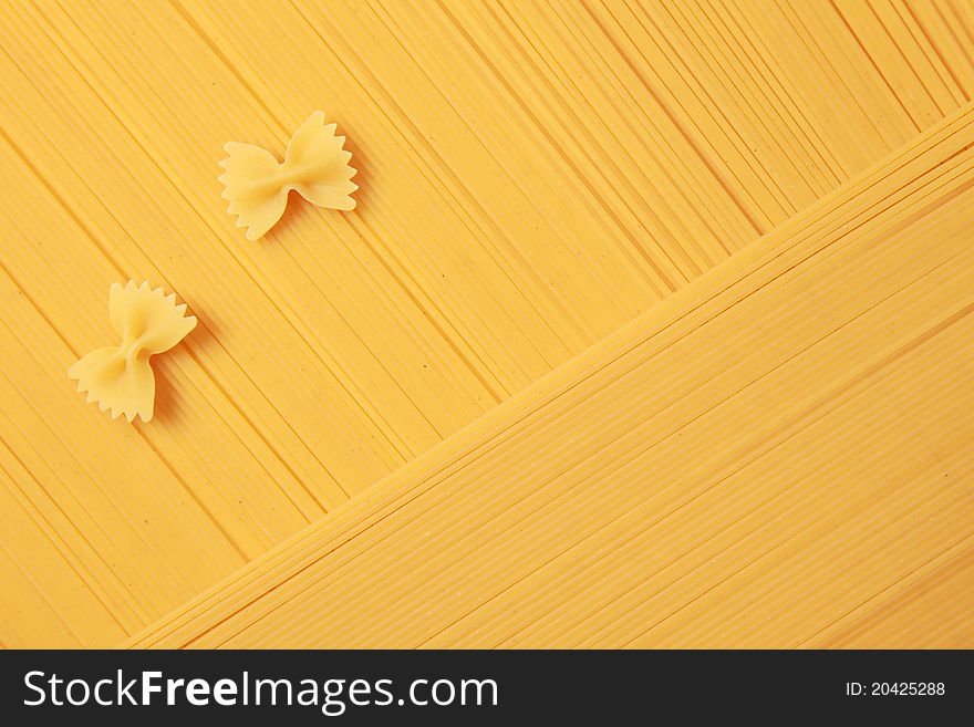 Two farfalle noodles are lying on spaghetti. Two farfalle noodles are lying on spaghetti