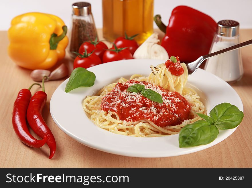 Fresh spaghettis are served with tomato sauce, basil and Parmesan cheese. Fresh spaghettis are served with tomato sauce, basil and Parmesan cheese.