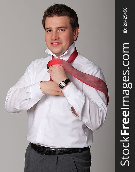 Portrait of young businessman standing against isolated white background