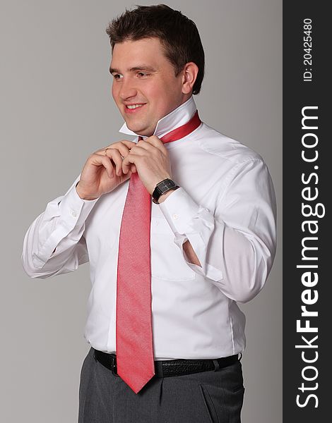 Portrait of young businessman standing against isolated white background