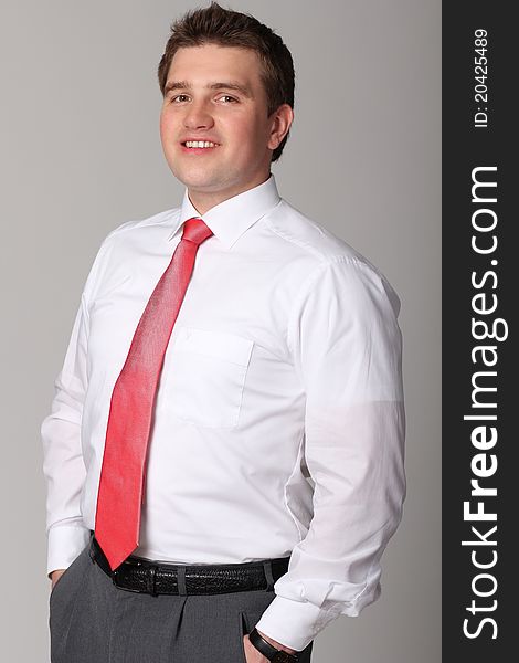Portrait of young businessman standing against isolated white background