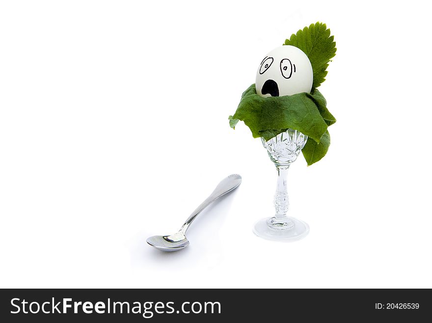 Egg with comic face and a teaspoon on white background