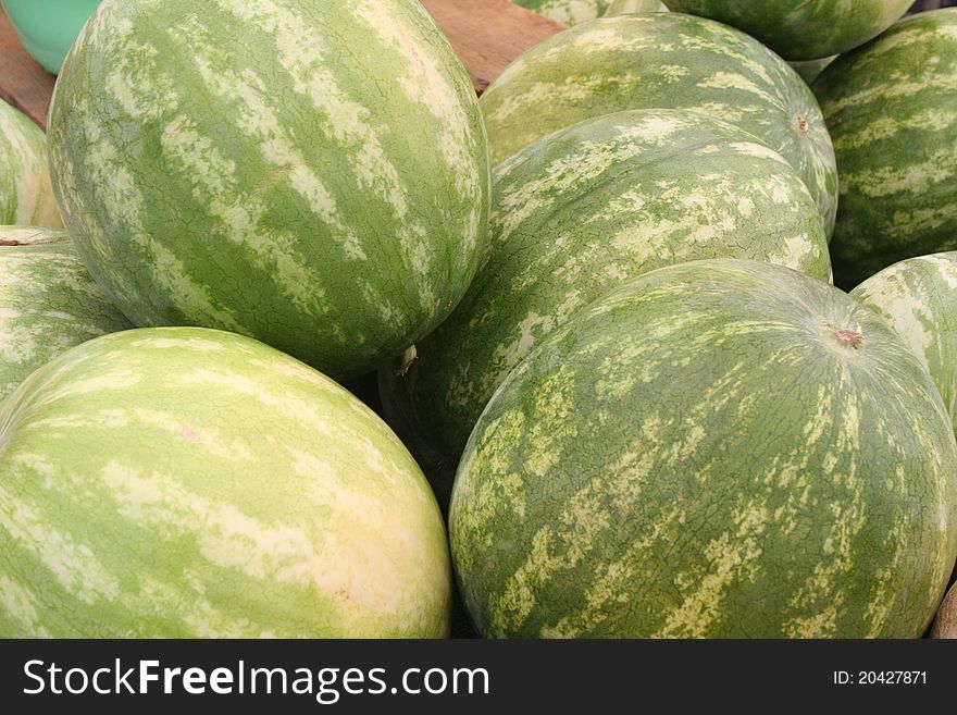 Stack of watermelons at an open air market.