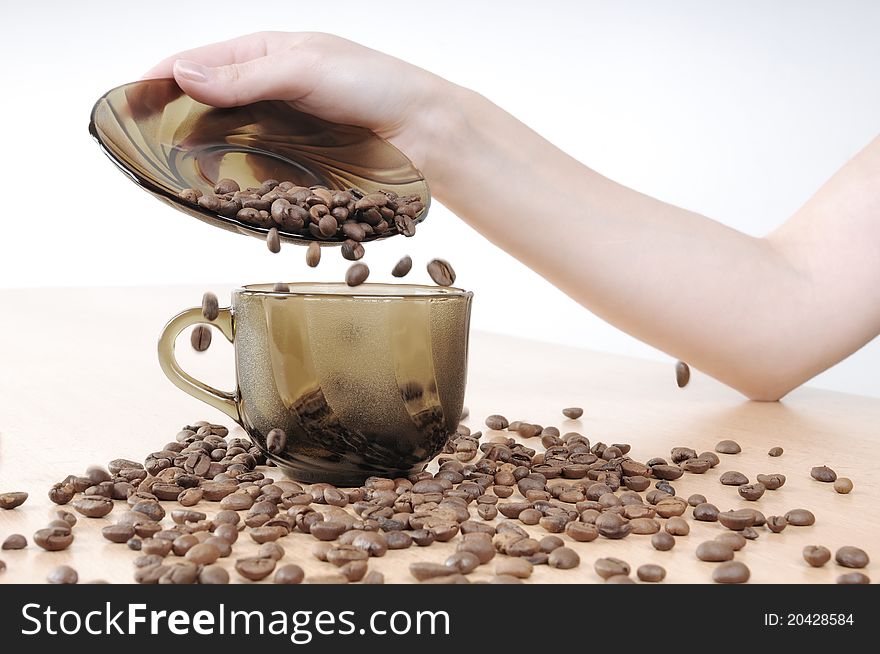 Hands pours coffee into a coffee cup on the table