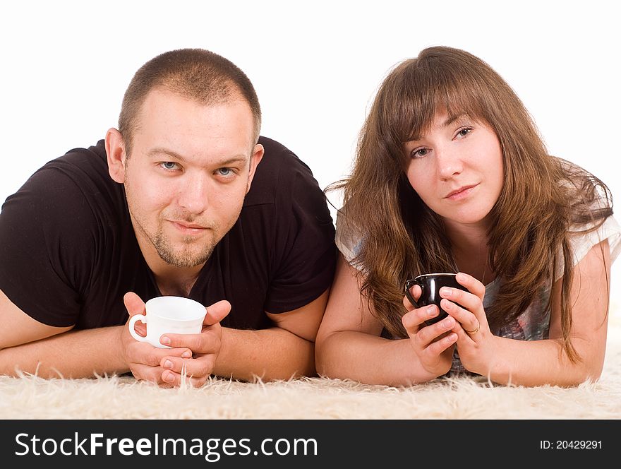 Happy cute couple drinking on a carpet. Happy cute couple drinking on a carpet