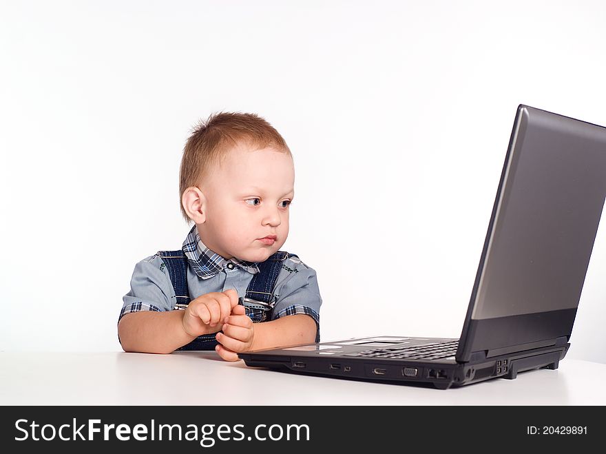 Little boy with a computer on a white. Little boy with a computer on a white