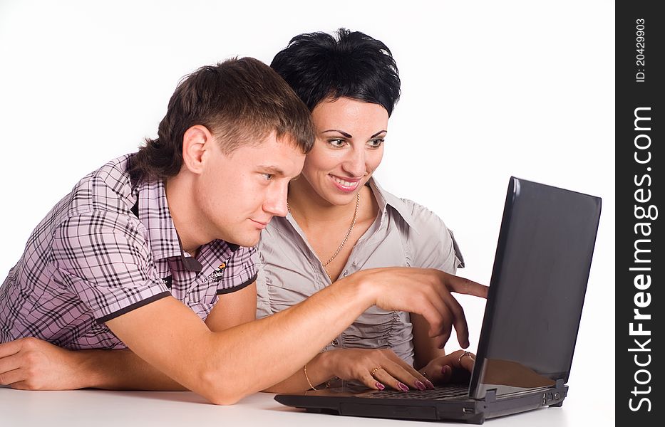 Young couple with a laptop on a white. Young couple with a laptop on a white