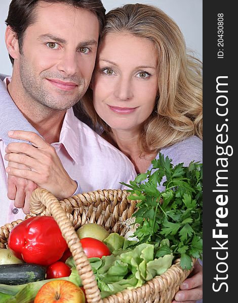 Couple holding basket of vegetables. Couple holding basket of vegetables
