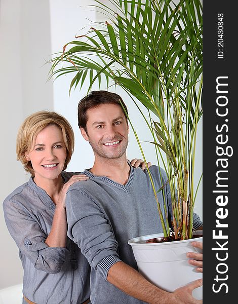 Man carrying a plant and happy woman. Man carrying a plant and happy woman