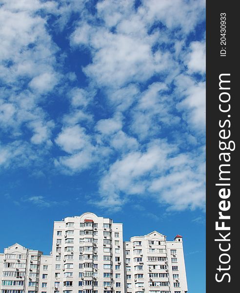 Modern apartment house against the sky with clouds in a city. Modern apartment house against the sky with clouds in a city.