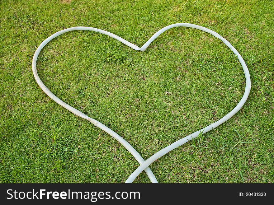 Green grass texture background with heart.