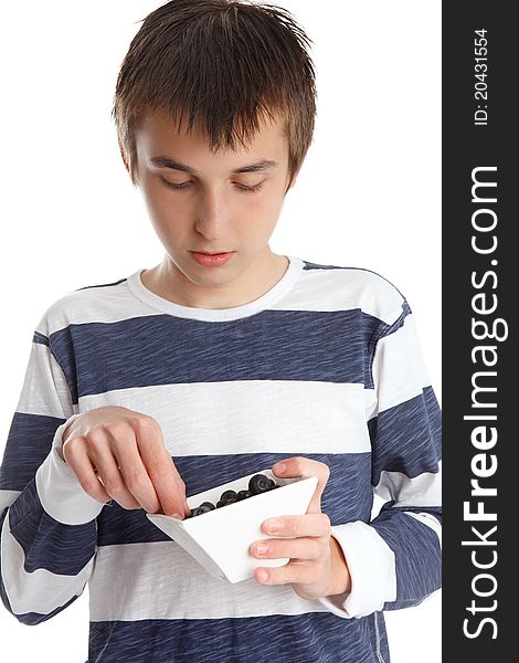 A child eats fresh blueberries from a small white bowl. A child eats fresh blueberries from a small white bowl.