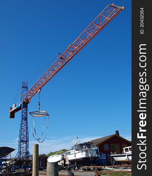 Red and blue boat lifting crane in Sweden.