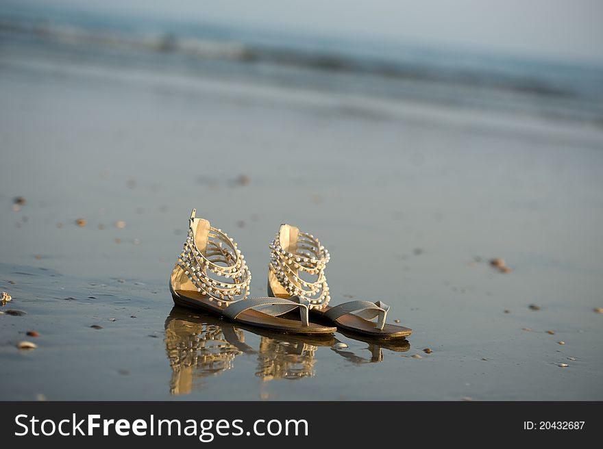 Shoes in the water on beach. Shoes in the water on beach