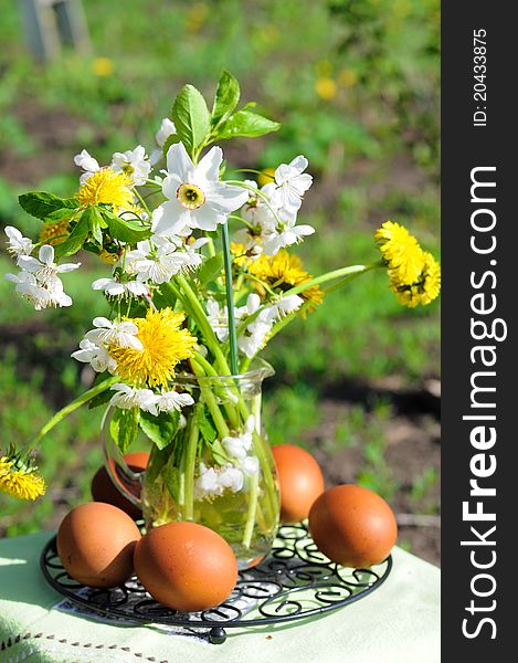 Bouquet of spring flowers and painted eggs. Еaster eggs are coloured with natural dyes - onion peel. Bouquet of spring flowers and painted eggs. Еaster eggs are coloured with natural dyes - onion peel.