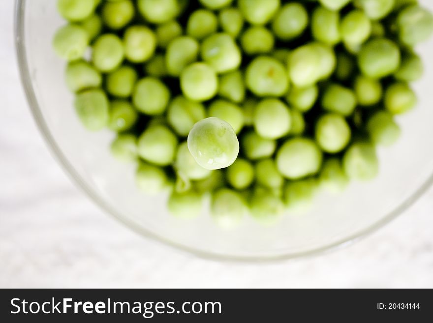 Pea falling among other peas in the bowl