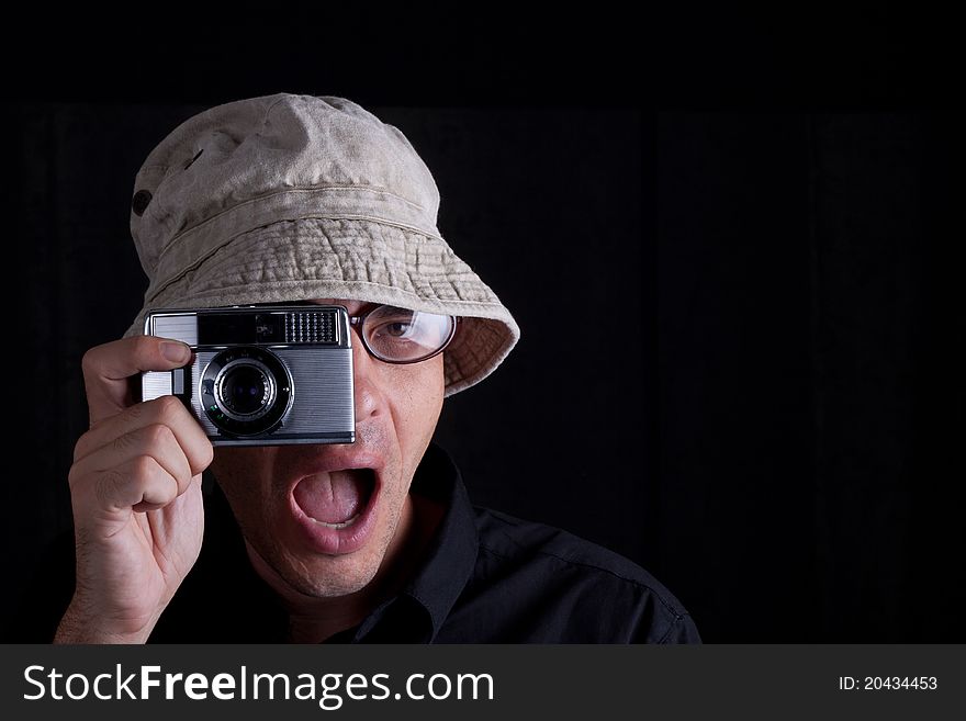 Photographer with hat an old camebra on black background