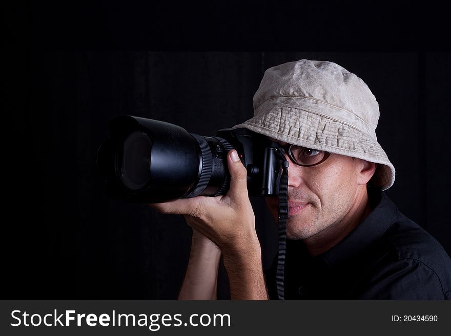 Photographer with hat and big camebra on black background. Photographer with hat and big camebra on black background