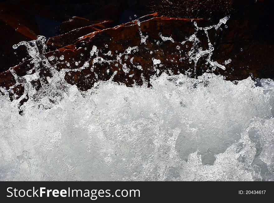 An abstract o splashing water and red rocks. An abstract o splashing water and red rocks