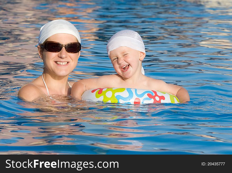 Mother with baby are swimming in pool. Mother with baby are swimming in pool