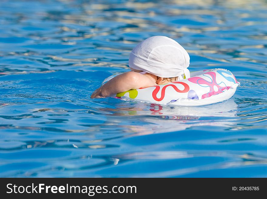 Baby is swimming in pool with inflatable tube. Baby is swimming in pool with inflatable tube