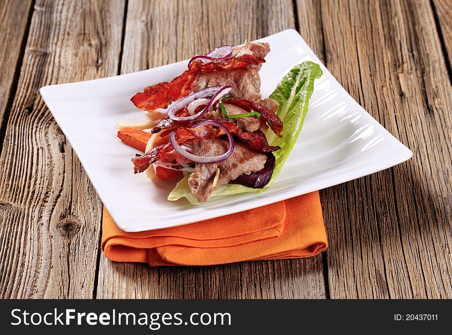 Shish kebab with crispy rashers of bacon and vegetables