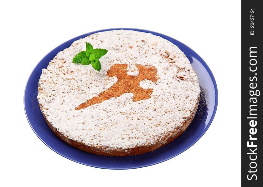 Nut cake dusted with powdered sugar (symbol on a top) on a blue plate - cut out on white