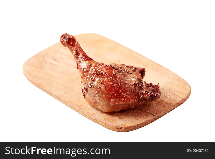 Roast leg of duck with crispy skin on a chopping board - cut out on white. Roast leg of duck with crispy skin on a chopping board - cut out on white