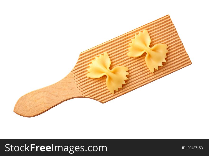 Bow tie pasta on a wooden cutting board - cut out on white