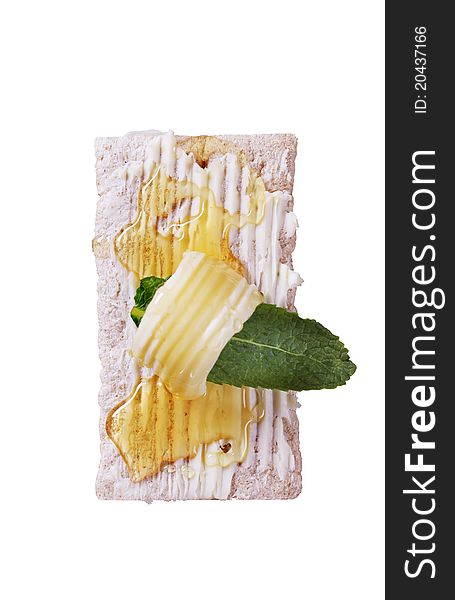 Slice of crispbread, butter and honey - overhead, cut out on white. Slice of crispbread, butter and honey - overhead, cut out on white
