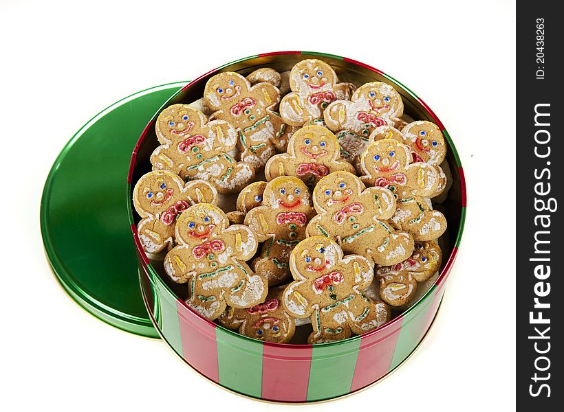 An overhead view of an opened red and green tin stuffed with gingerbread cookies.  Isolated on white. An overhead view of an opened red and green tin stuffed with gingerbread cookies.  Isolated on white.