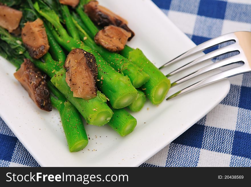 Macro of Asian style vegetarian delicacy with stemmed vegetables and sliced seasoned mushrooms. Macro of Asian style vegetarian delicacy with stemmed vegetables and sliced seasoned mushrooms.