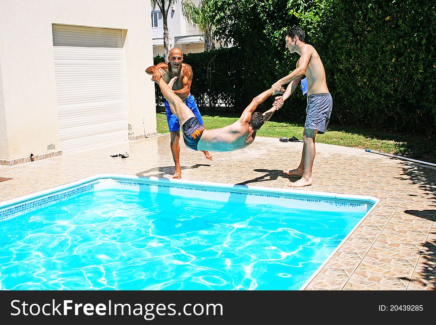 Men  throwing  their friend to swimming pool. Men  throwing  their friend to swimming pool.