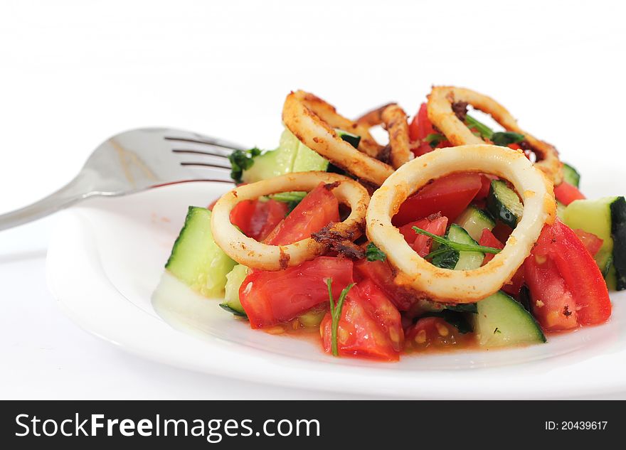 Squid salad in a plate with fork on white