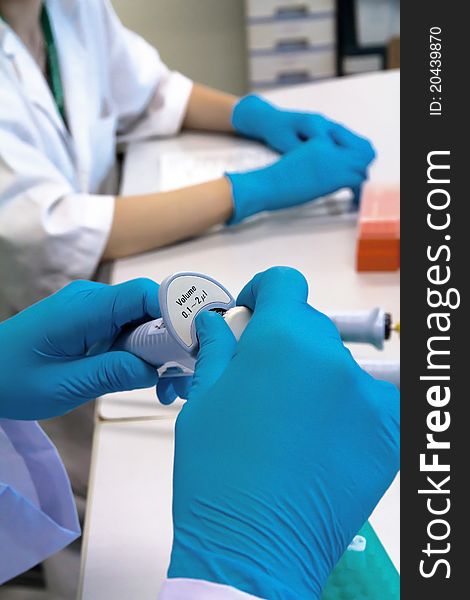 Researcher holding pipette in a science research lab