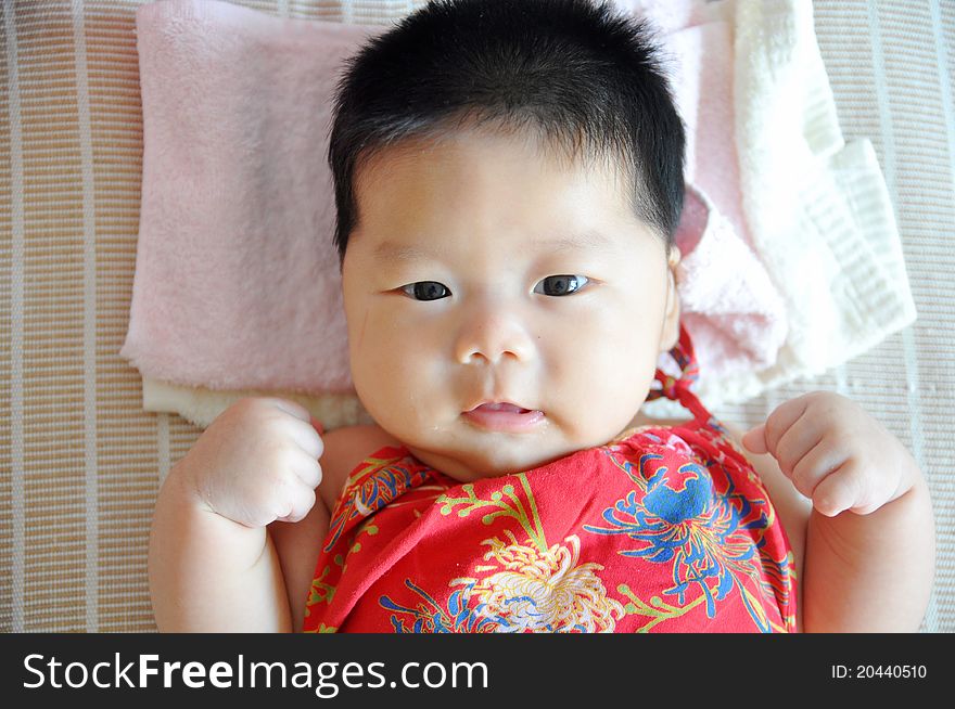 A 2 months chinese Baby girl lying on the bed