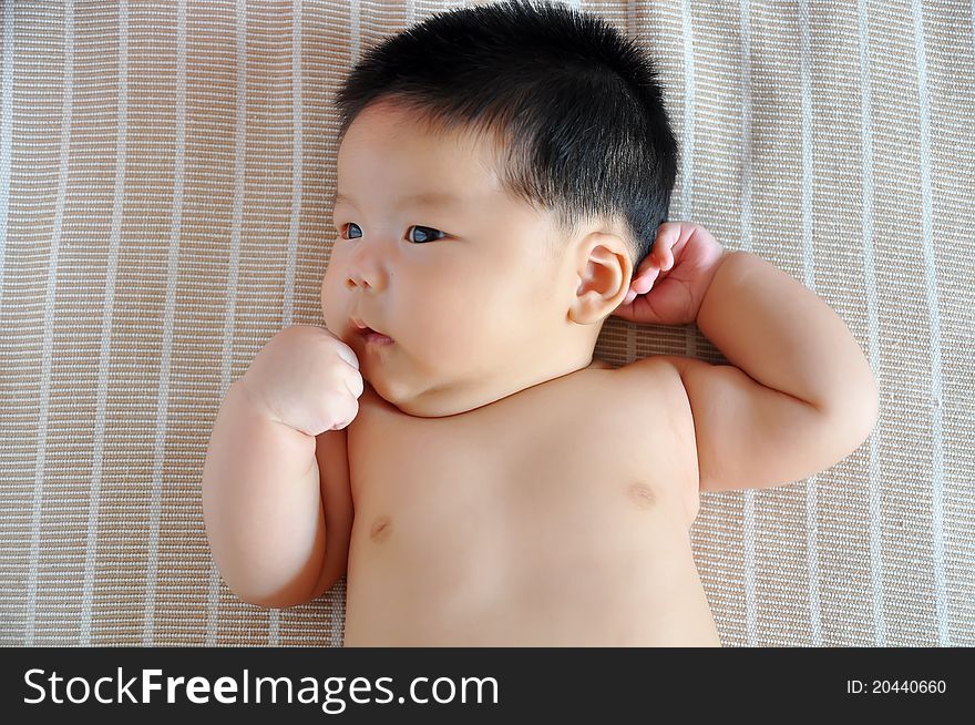 A 2 months chinese Baby girl lying on the bed