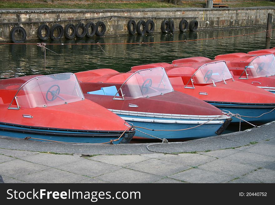 Red and blue paddleboats on a lake