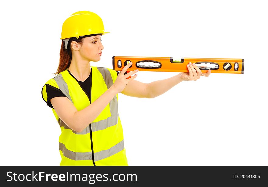 A females dressed in a high visibility vest looking along a spirit level on isloated white background. A females dressed in a high visibility vest looking along a spirit level on isloated white background