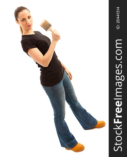 A young femaled dressed in blue jeans and black top holding a paint brush on isloated white background. A young femaled dressed in blue jeans and black top holding a paint brush on isloated white background