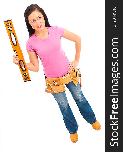 A young female dressed pin pink top and blue jeans wearing a tool belt holding a spirit level on isolated white background. A young female dressed pin pink top and blue jeans wearing a tool belt holding a spirit level on isolated white background