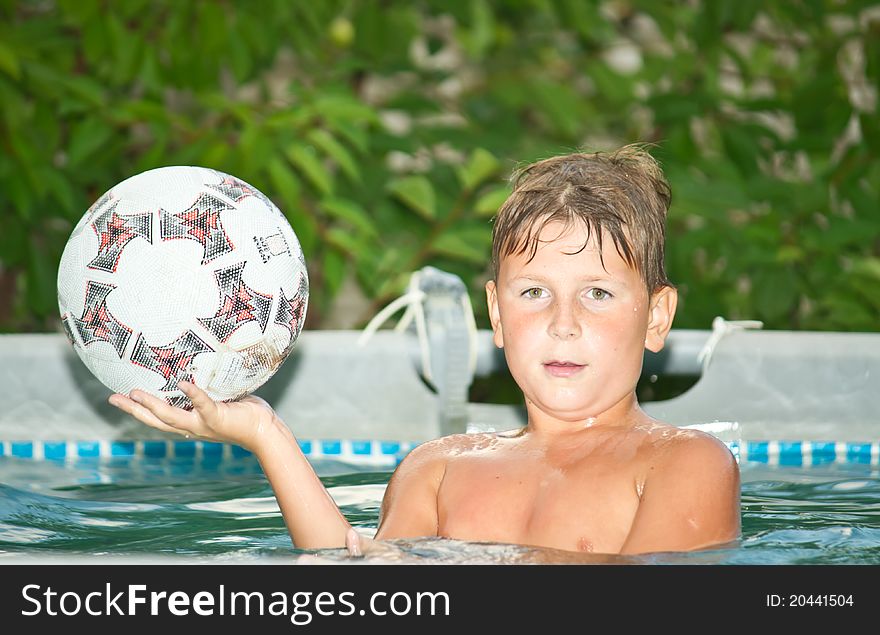 Boy in the pool holding a ball
