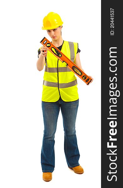 A female dressed in a high visibility vest looking a t a spirit level on isloated white background. A female dressed in a high visibility vest looking a t a spirit level on isloated white background