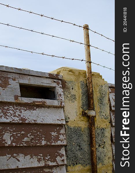 A barb wire security fence on top of a wall around a heavily secured property.